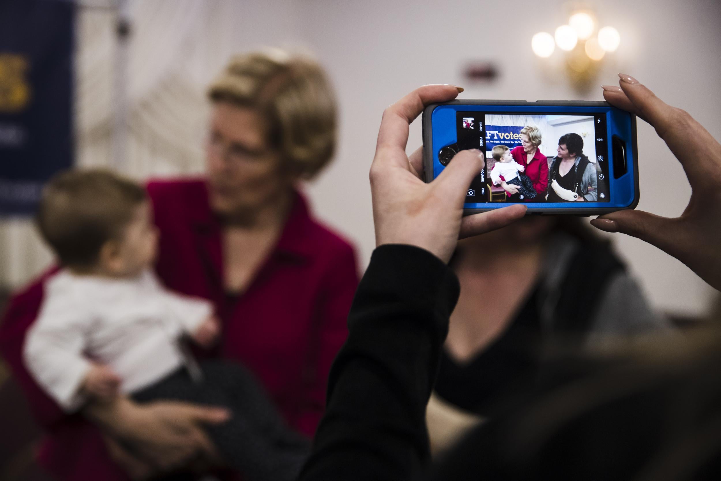 Warren holds a baby during a selfie line in Philadelphia (Associated Press)