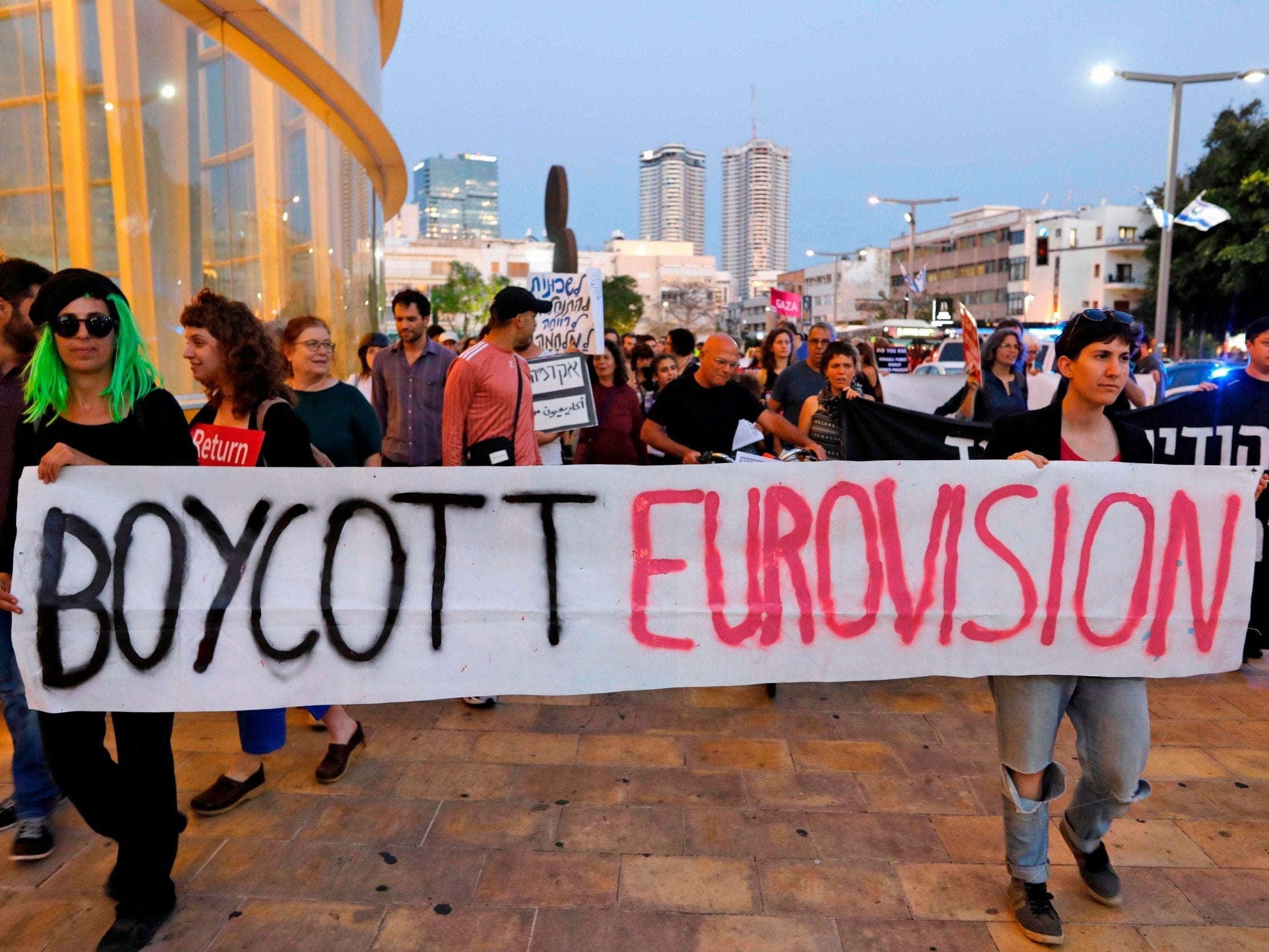 Left wing Israelis hold slogans during a protest against Eurovision on May 14, 2019 in Tel Aviv.