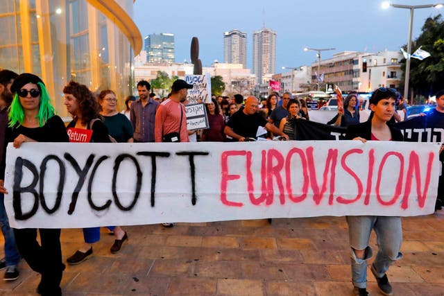 Left wing Israelis hold slogans during a protest against Eurovision on May 14, 2019 in Tel Aviv.