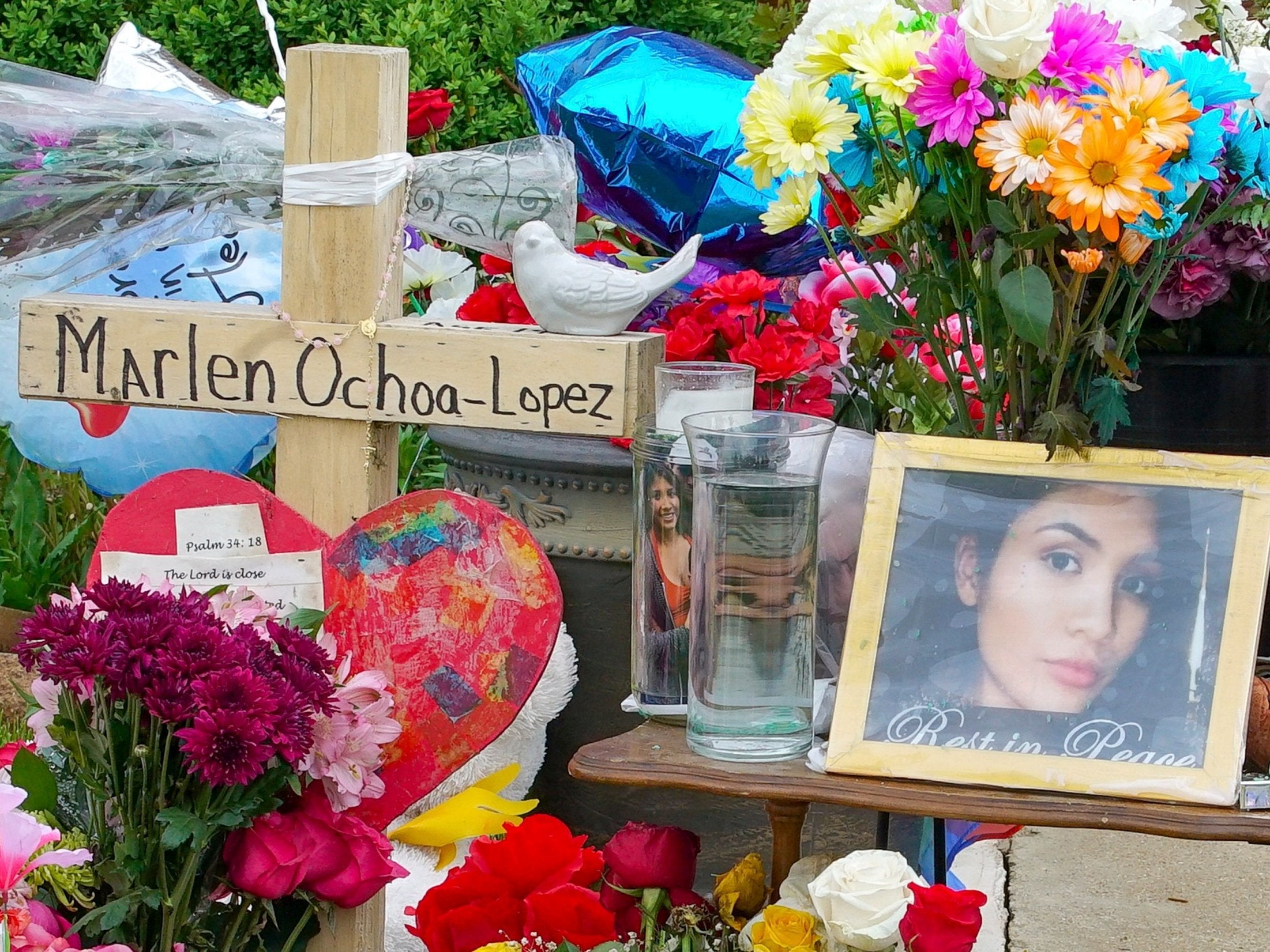 A memorial of flowers, balloons, a cross and photo of victim Marlen Ochoa-Lopez, are displayed on the lawn