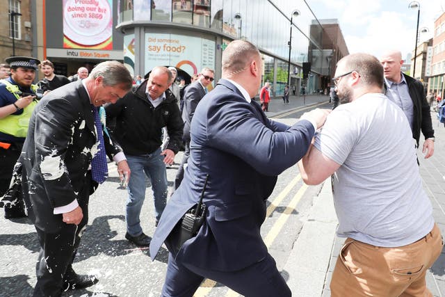 Brexit Party leader Nigel gestures after being hit with a milkshake while arriving for a Brexit Party campaign event in Newcastle