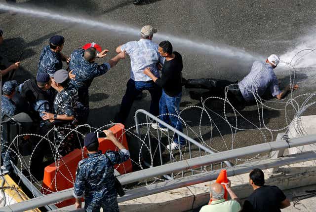 Lebanese police use a water cannon against protesters, including retired army officers, demonstrating against budget cuts