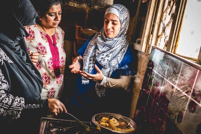 Asma Khan (middle) cooking with two refugees