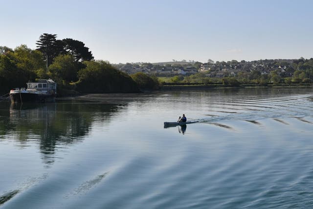 A man in a canoe paddles down the River Torridge in Devon