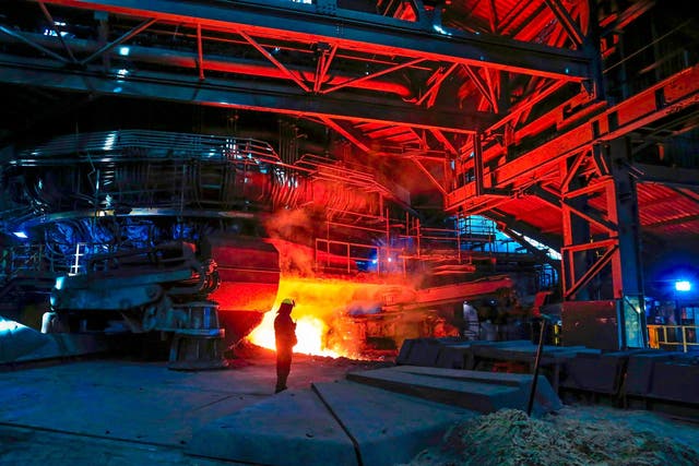 A British Steel worker watches as molten metal is poured from one of the blast furnaces in Scunthorpe
