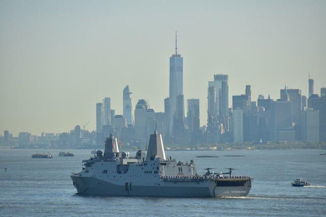 USS New York sails across the city's harbour, with One World Trade Center in the background