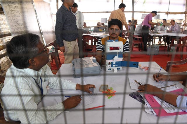 An Indian election official shows an open Electronic Voting Machine (EVM) to polling agents at a counting centre in Ghaziabad