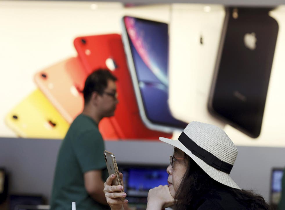 A customer looks at her iPhone at an Apple store in Beijing