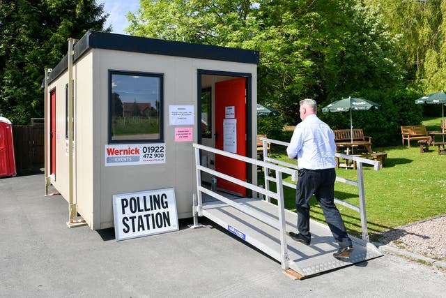 A man enters a temporary polling station in a pub beer garden at the Swan Inn, Coombe Hill, Gloucestershire