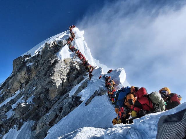 <p>Climbers line up to stand at the summit of Mount Everest</p>