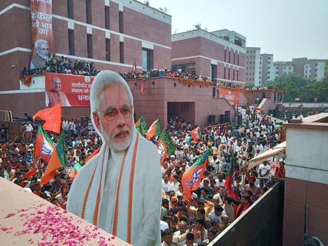 Party workers celebrate a landslide victory with a larger-than-life cardboard cutout of Modi at BJP headquarters in Delhi