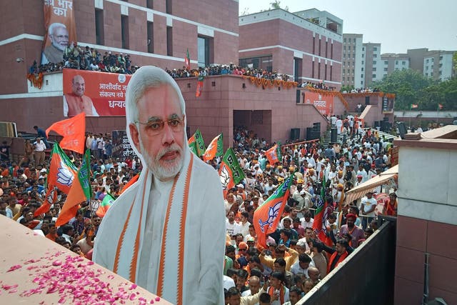 Party workers celebrate a landslide victory with a larger-than-life cardboard cutout of Modi at BJP headquarters in Delhi