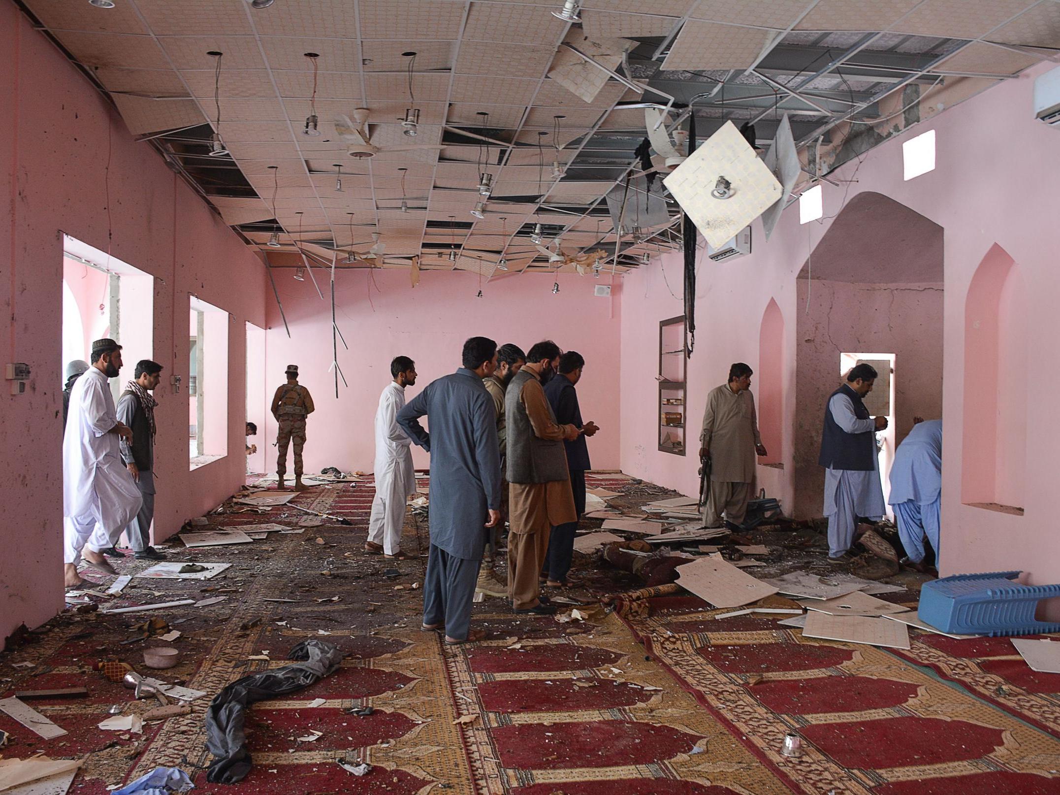 Pakistani officials examine interior of a mosque struck by blast which killed two people and injured 14