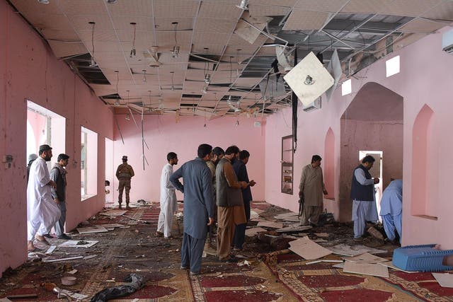Pakistani officials examine interior of a mosque struck by blast which killed two people and injured 14