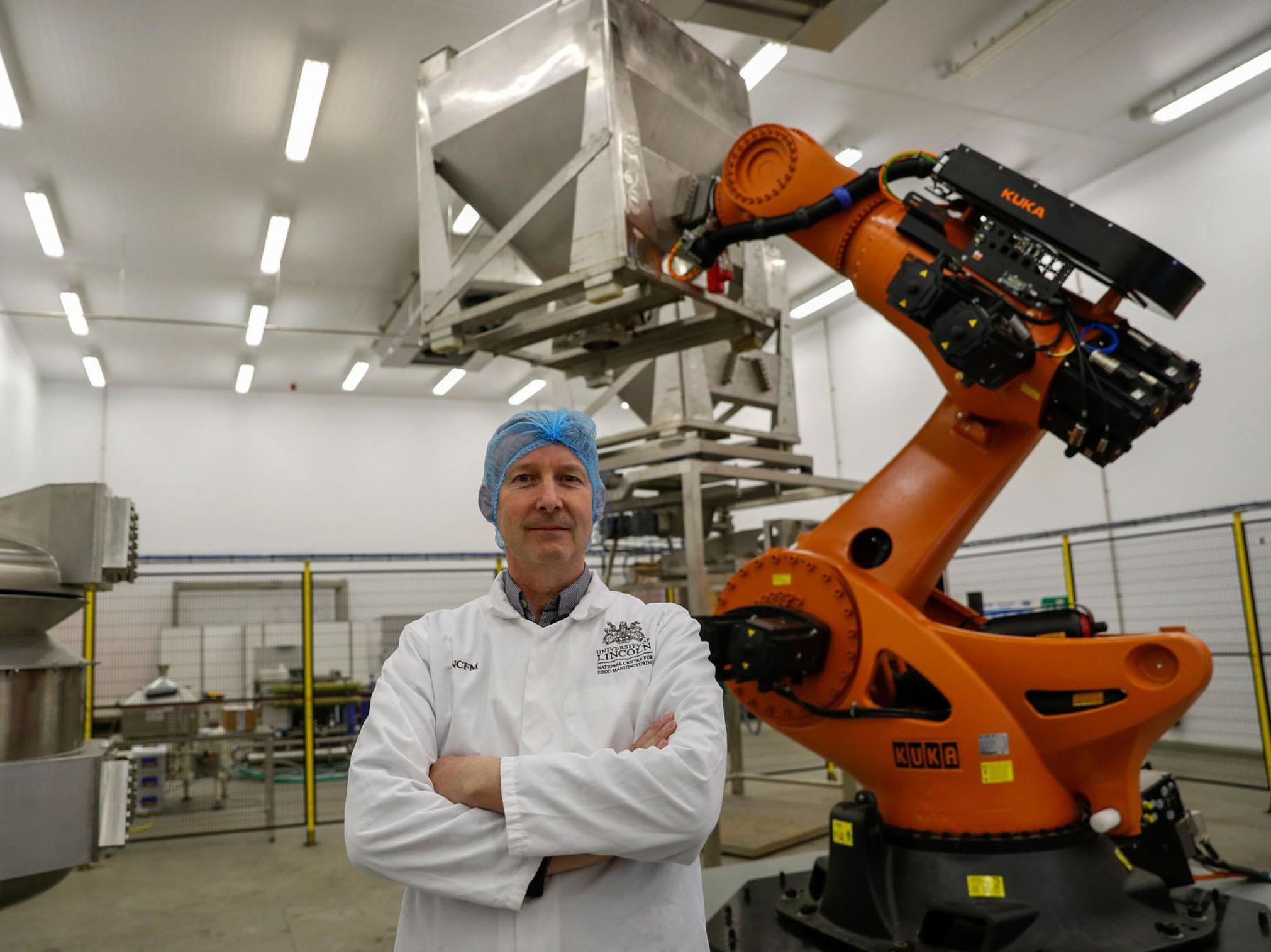 Product development chef Chris Brooks with a ‘robotic chef’ at the National Centre for Food Manufacturing in Holbeach, Lincolnshire
