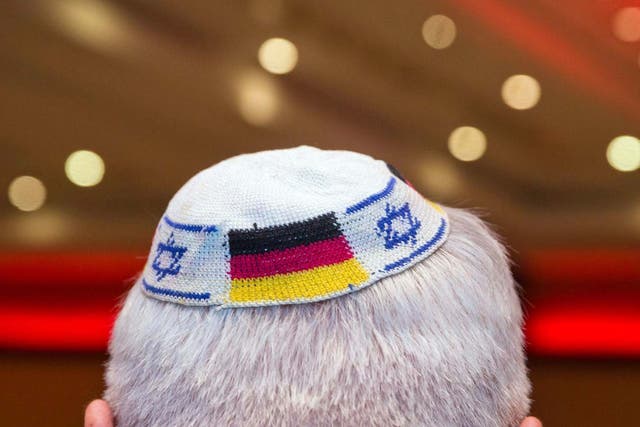 A man wears a Jewish skullcap with the flags of Germany and Israel