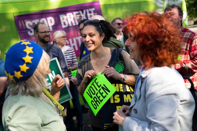 Supporters of the Green Party alongside an electric-powered campaign bus at a European parliament elections campaign event, in Brighton
