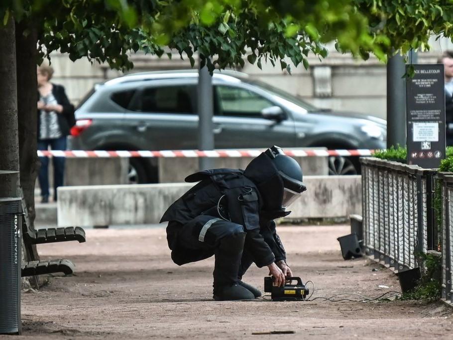 A bomb disposal expert works at the scene of a suspected package bomb blast along a pedestrian street in the heart of Lyon, southeast France, on 24 May, 2019