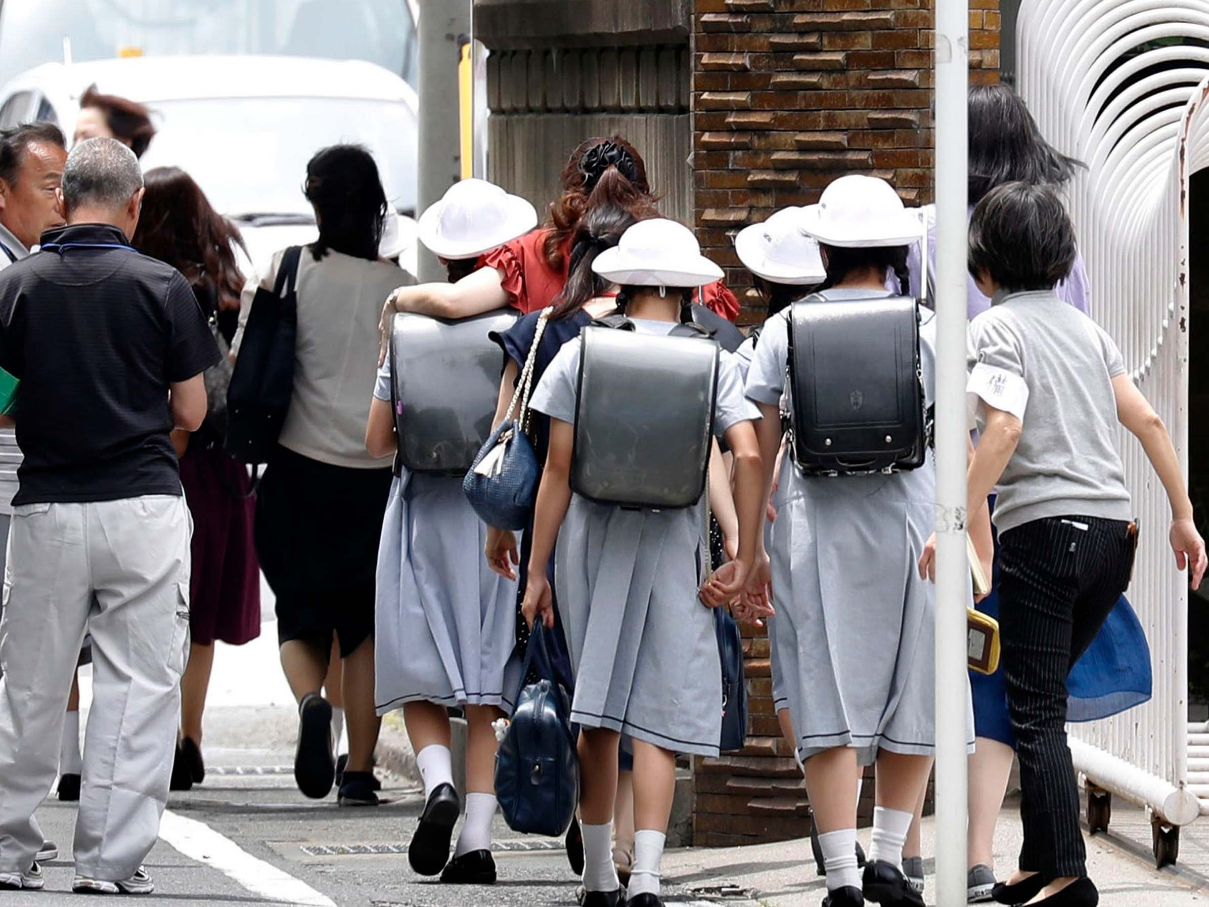 CARITAS Elementary School students leave their school with parents following an stabbing at a bus stop in Kawasaki, near Tokyo, Japan, 28 May 2019.