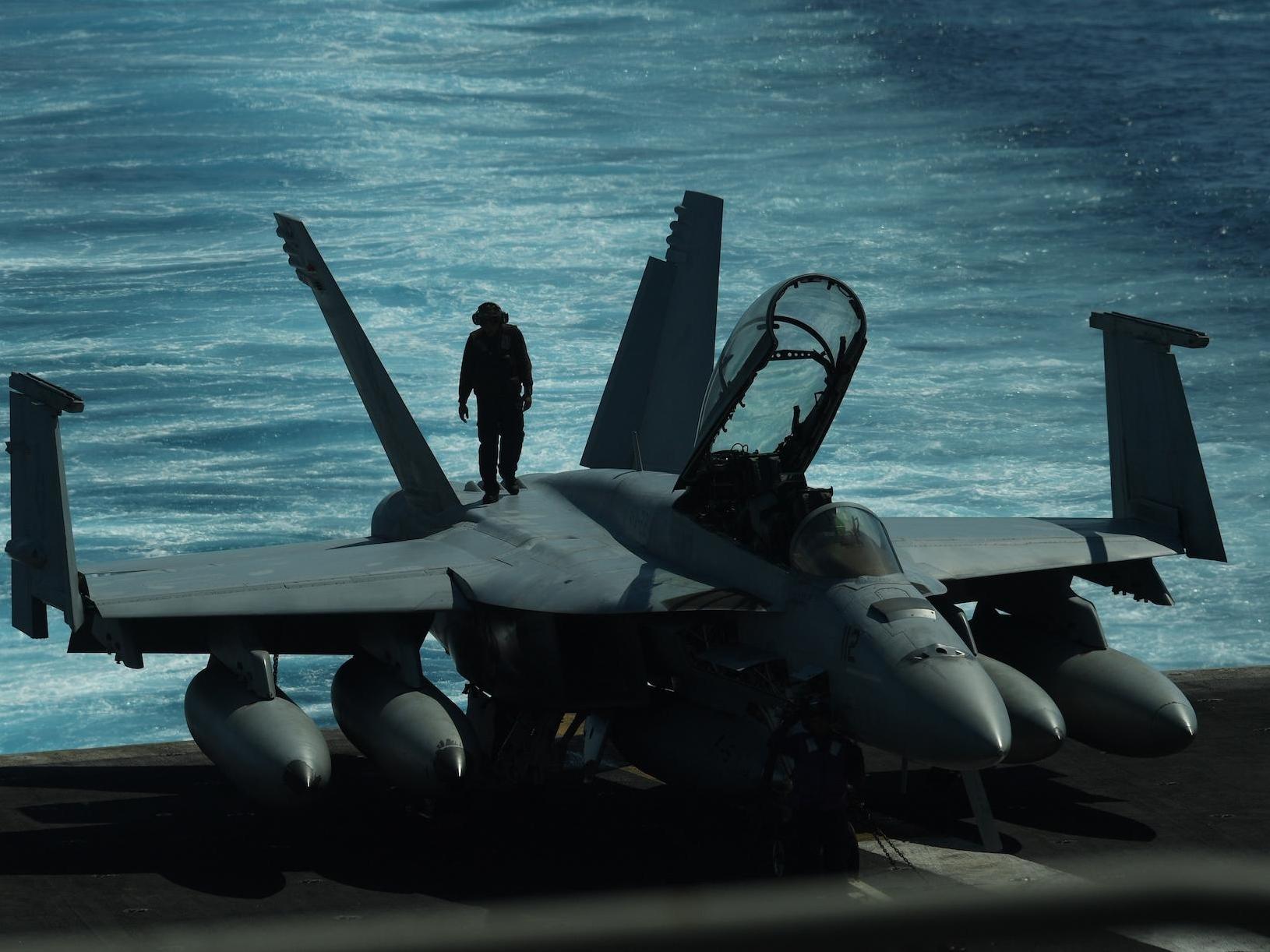 A US sailor inspects a FA-18 hornet fighter jet during a routine training in the South China Sea. The US has stepped up its naval patrols in the region in recent months.