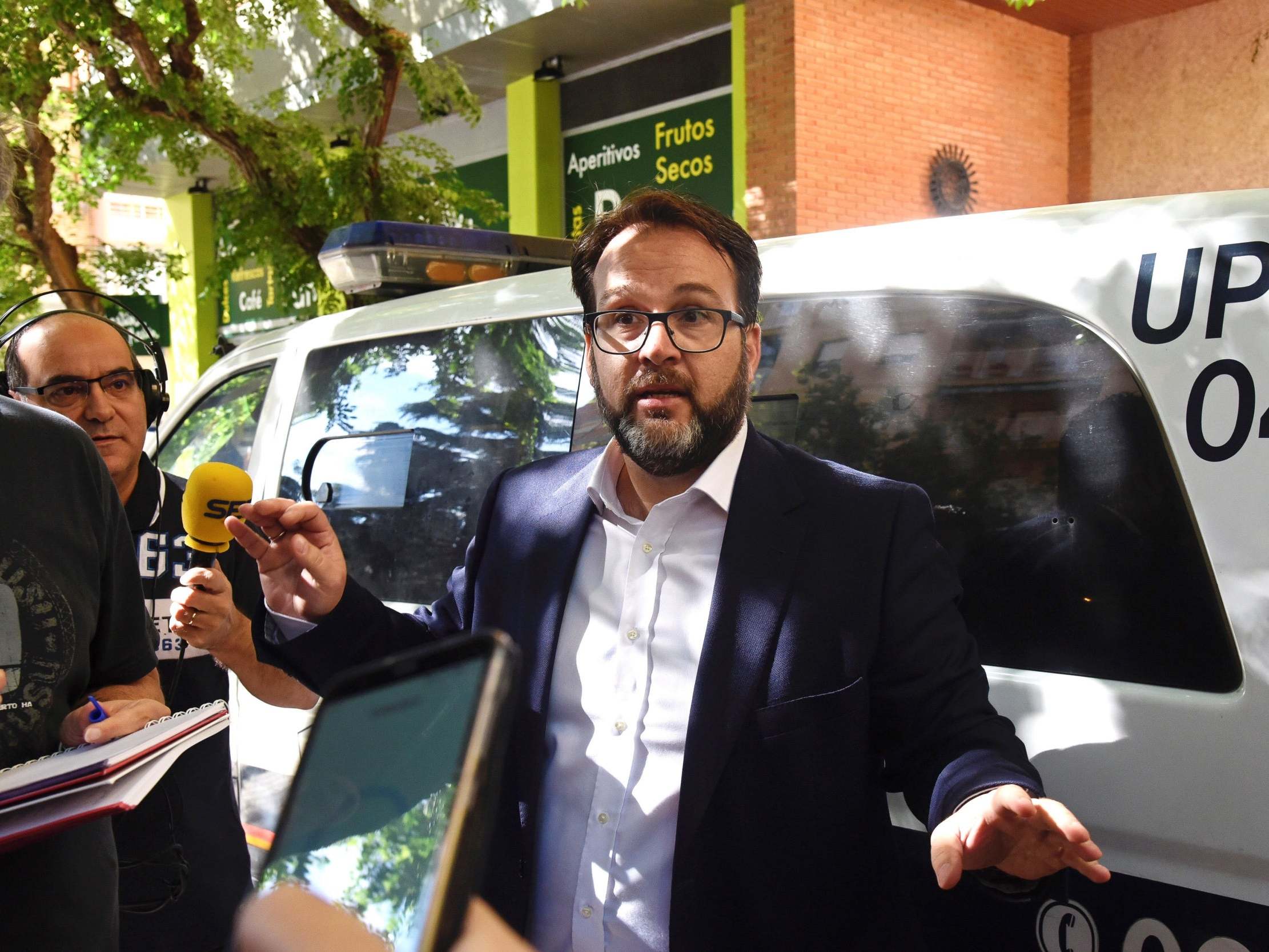 Huesca's lawyer Pedro Camarero talks to journalists in front of a police vehicle outside the club's headquarters