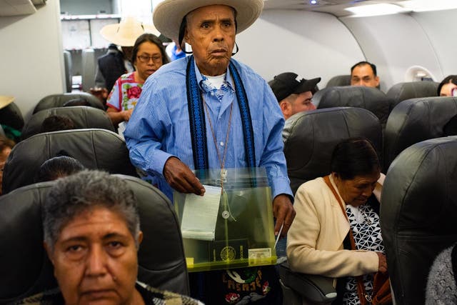 Eutimio Jasinto Campos, 78, of Cheranastico, looks for his seat on the plane: he hasn’t seen his son for 18 years