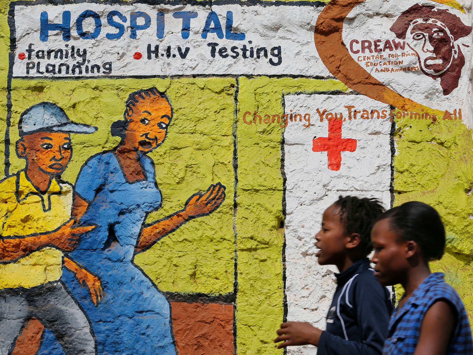 Women walk past a mural painted to raise awareness on HIV and Aids in Nairobi (EPA)