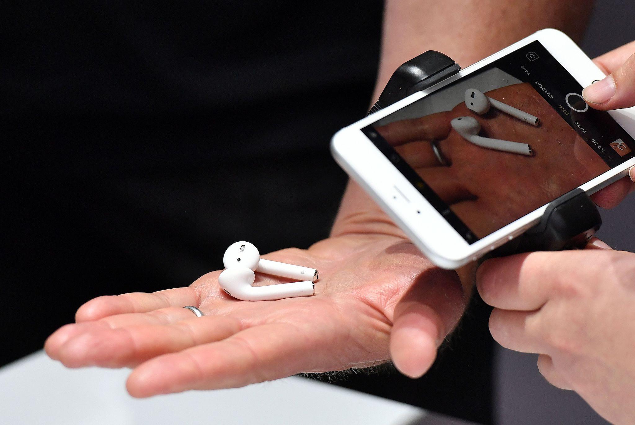 A person takes a photo of a set of wireless Apple AirPods during a media event at Bill Graham Civic Auditorium in San Francisco