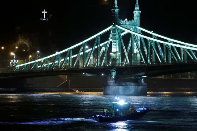 A rescue boat searches near the scene on the Danube river