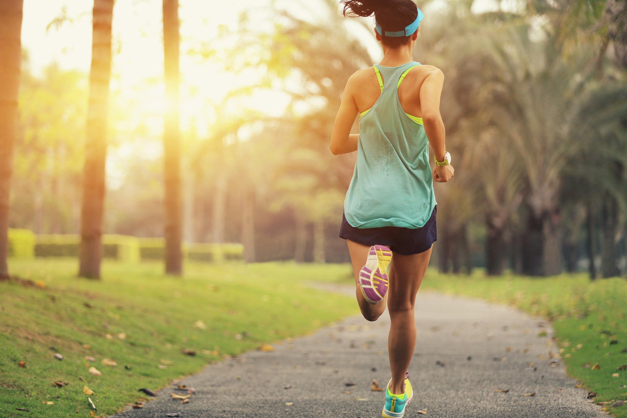 Healthy lifestyle young sporty woman running at tropical park