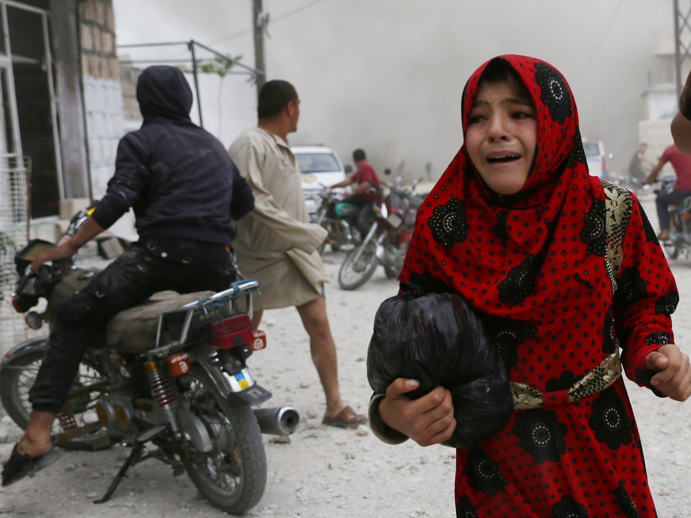 A Syrian girl runs for cover during an airstrike by pro-regime forces on Kfar Ruma last week