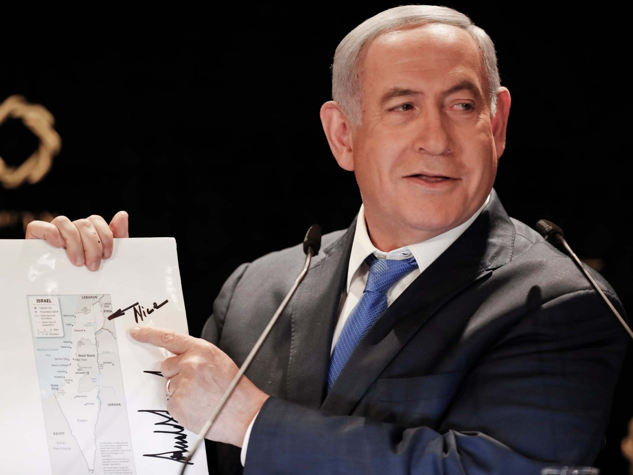 Israeli prime minister Benjamin Netanyahu points to the Golan Heights on a map of Israel signed by Donald Trump