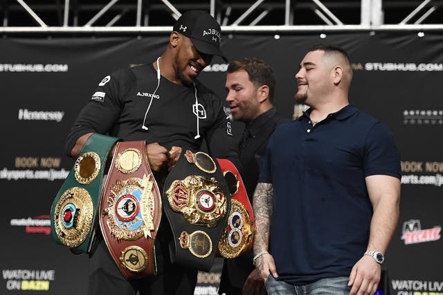 Anthony Joshua of the United Kingdom holds his belts while talking with Andy Ruiz of Mexico during the press conference prior to their world heavyweight title fight at the Beacon Theatre
