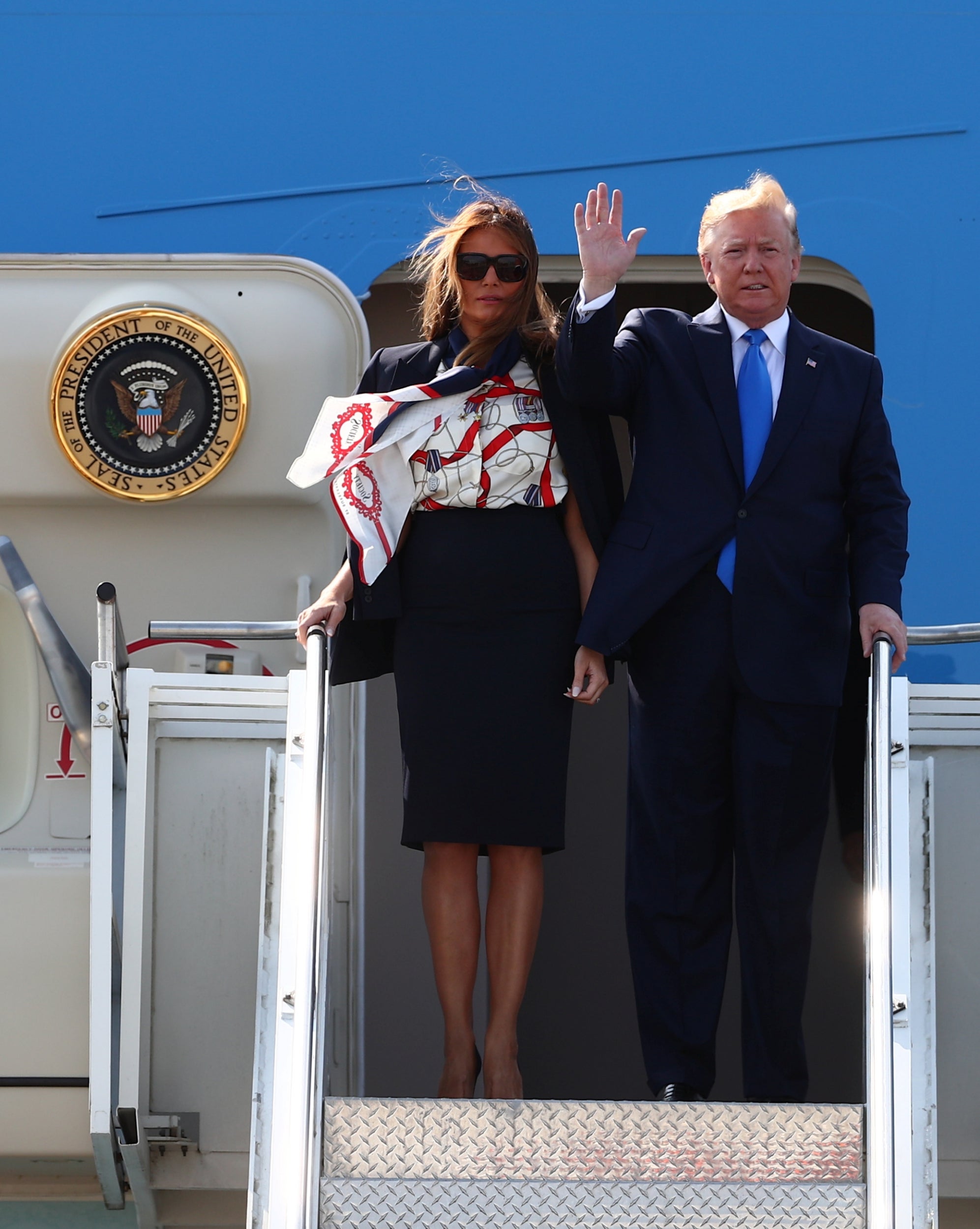 Melania arrived at London's Stansted airport wearing a navy-blue skirt suit paired with a printed pussy-bow blouse by British heritage brand Burberry.