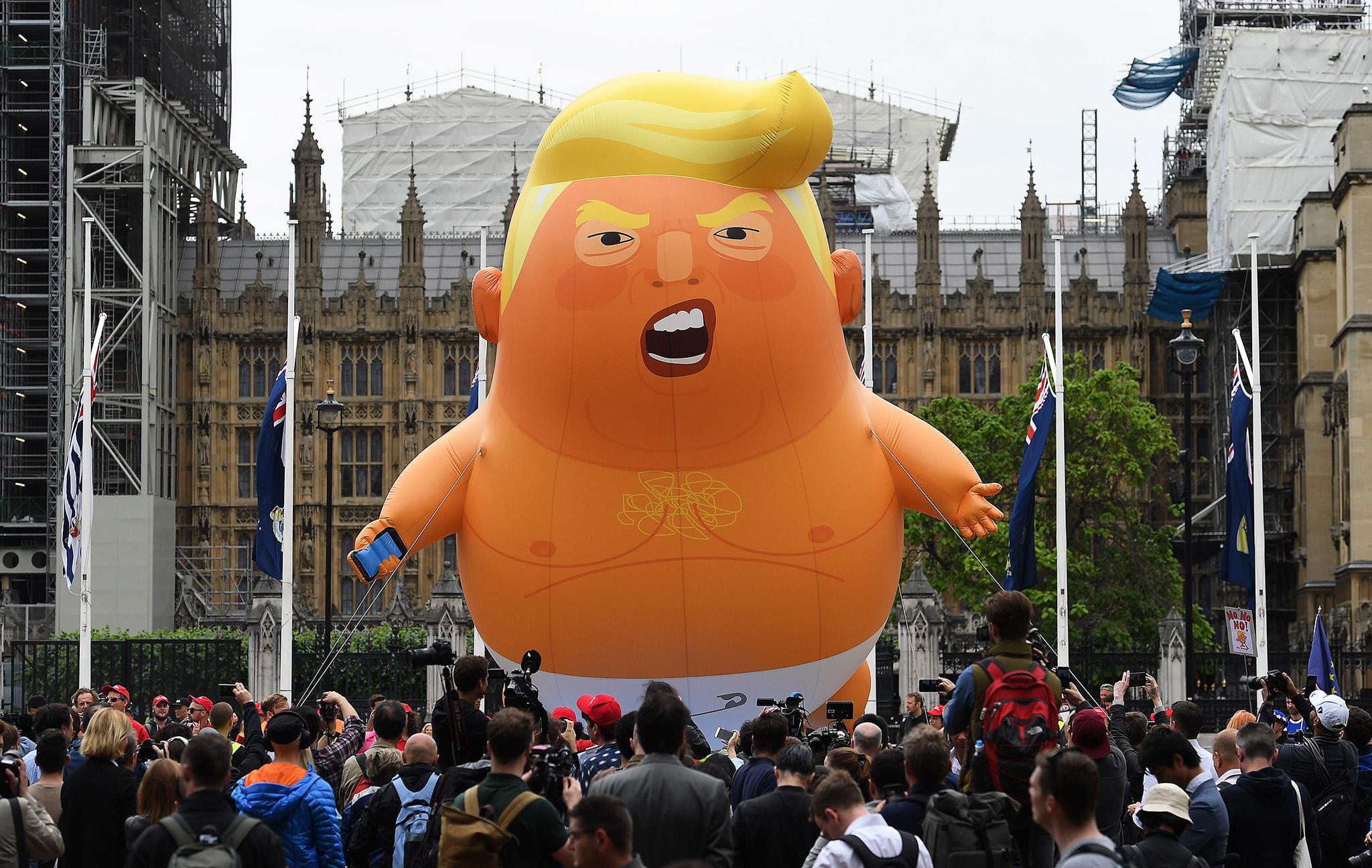 Protesters with a Trump baby blimp flying over Parliament Square