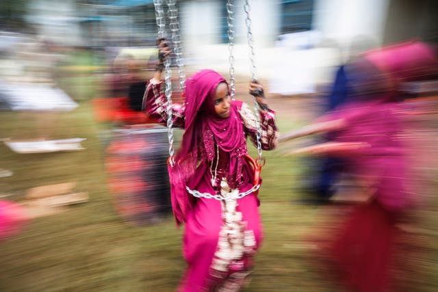 <p>A young Muslim girl enjoys a swing ride during an Eid celebration </p>