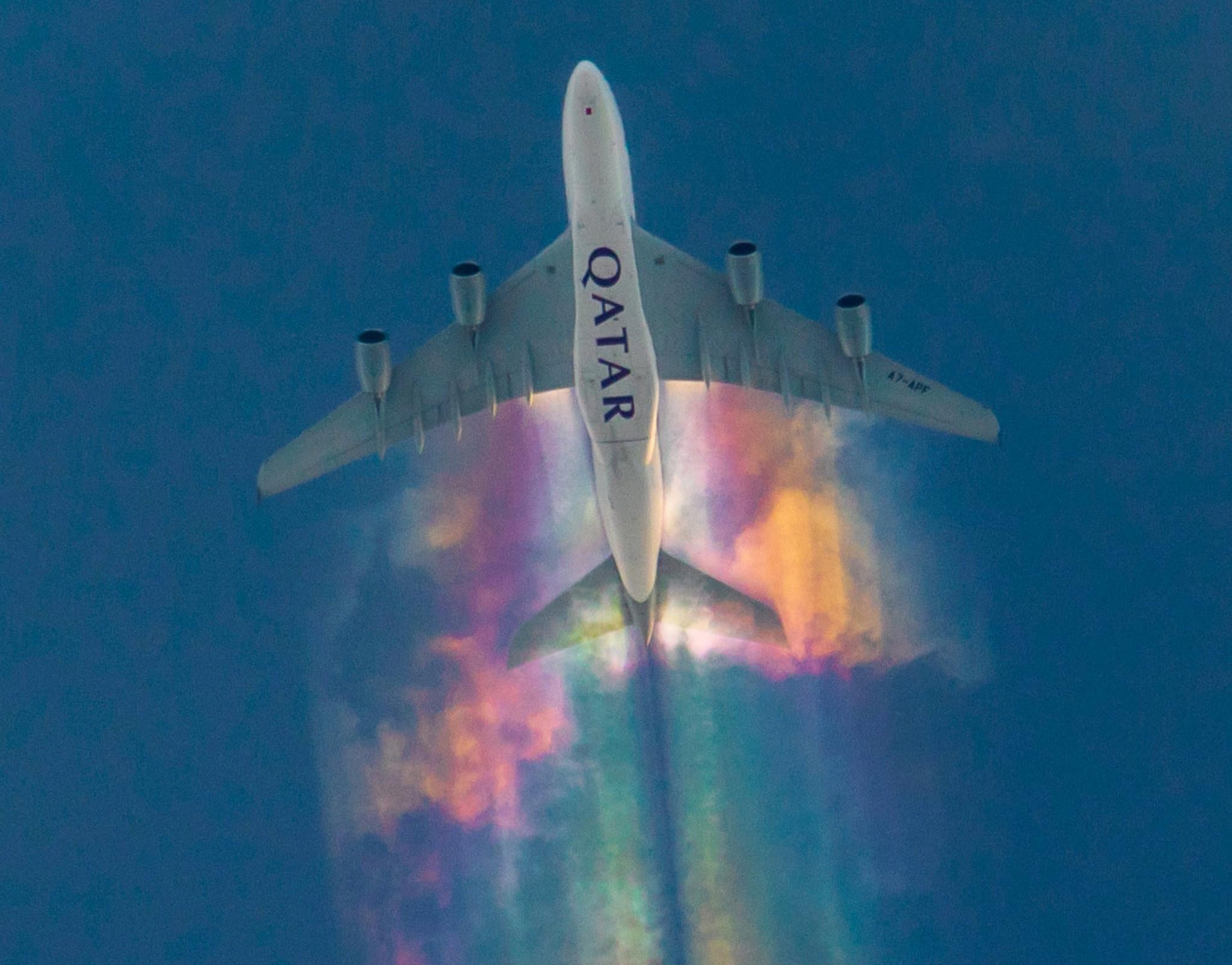 A passenger plane is pictured brightening the skies over Germany as it leaves behind a rainbow-coloured trail.