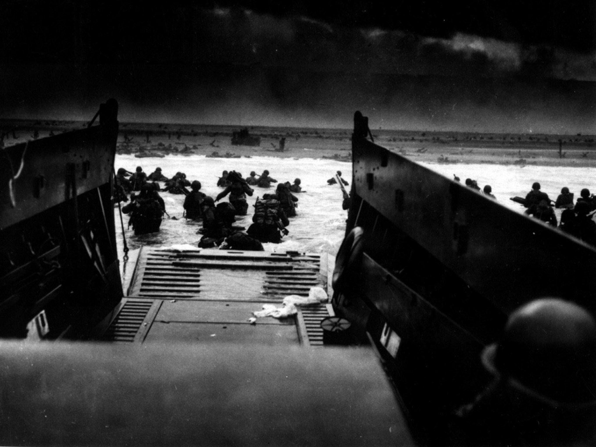 American soldiers leaving the ramp of a coast guard landing boat