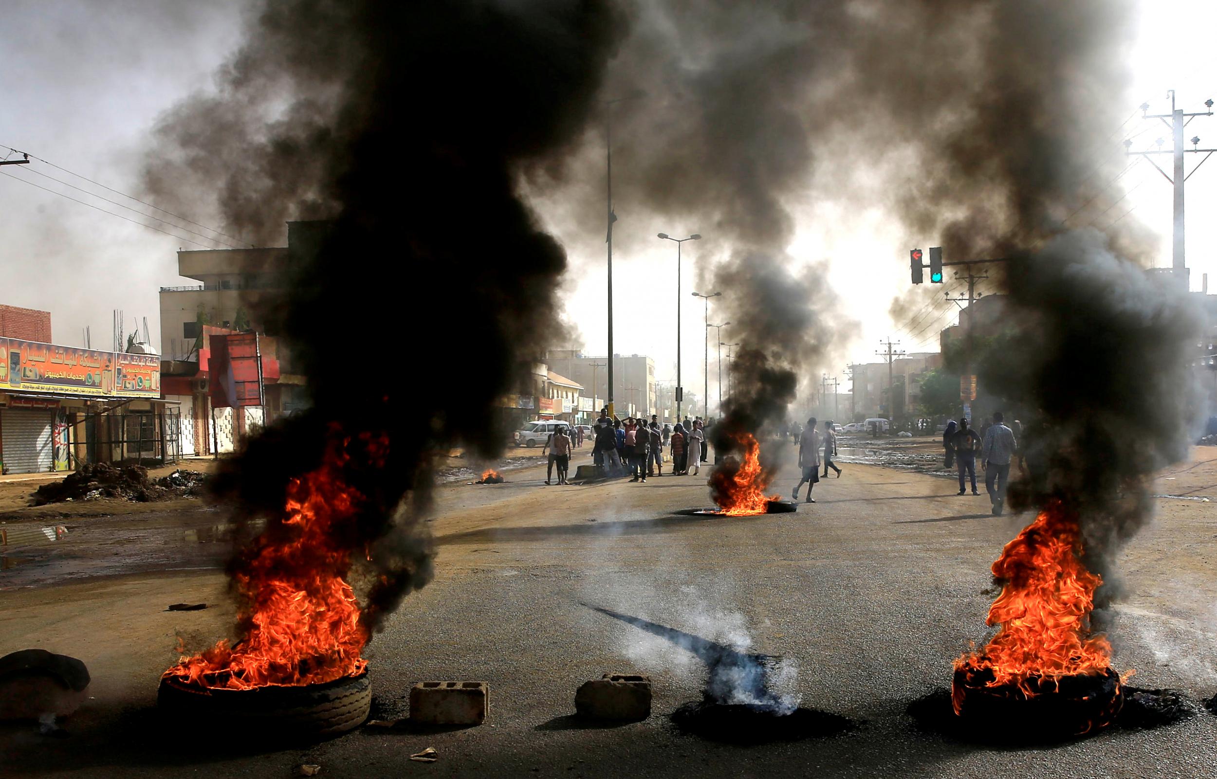 Sudanese protesters use burning tyres to erect a barricade on a street, demanding that the country’s Transitional Military Council hand over power to civilians