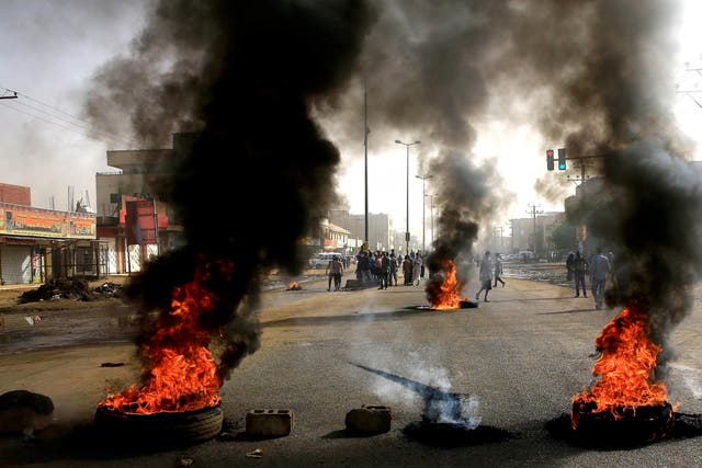Sudanese protesters use burning tyres to erect a barricade on a street, demanding that the country’s Transitional Military Council hand over power to civilians