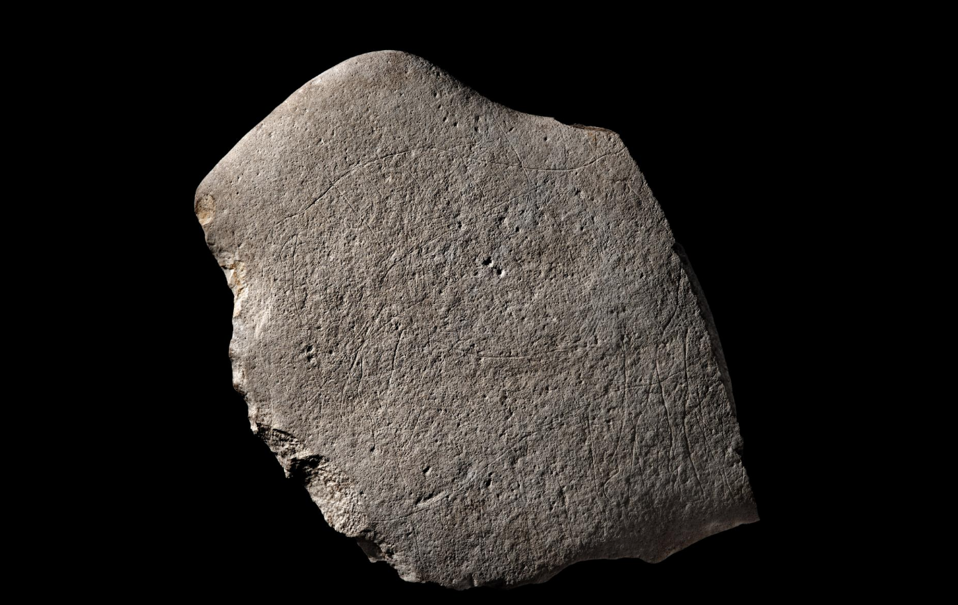 The stone with the engravings faintly visible on its surface
