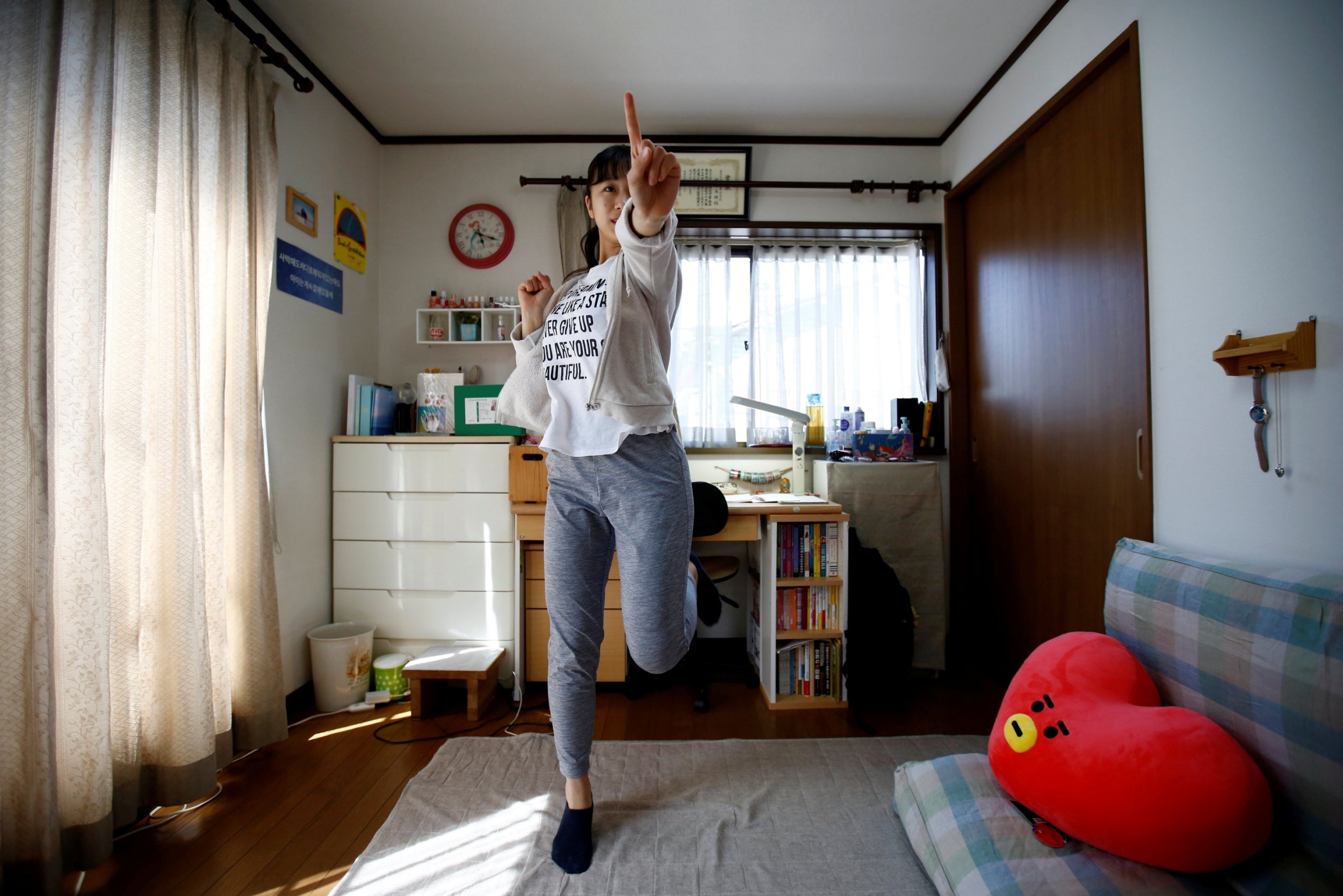 Nao Niitsu, 19, a college freshman from Tokyo, who wants to be a K-pop star, practices dancing to K-pop songs in her room in Tokyo. "I've heard stories about no free time or not being able to do what I want. But, I think all of K-pop stars who are now performing have gone down the same road," said Niitsu