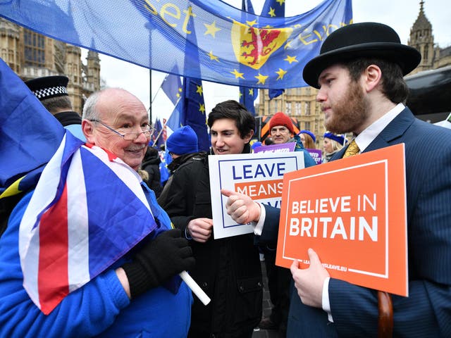 Pro-EU and pro-Brexit protestors discuss the vote near to the Houses of Parliament on January 29, 2019 in London, England.