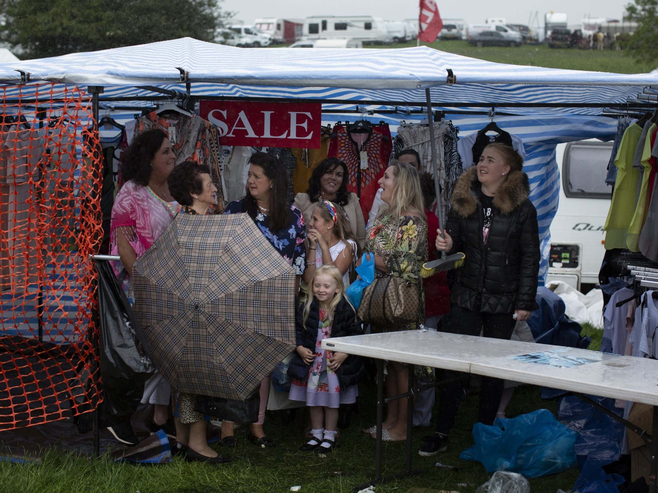 People shelter from rain during the Appleby Horse Fair, an annual gathering for Gypsy, Romany and Traveller communities that dates back to 1685