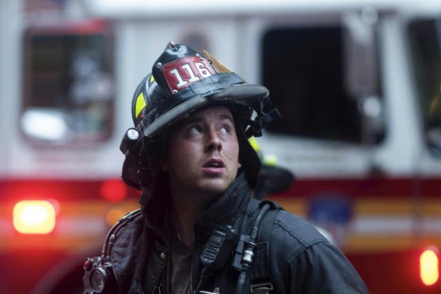 A firefighter looks up near a building where a helicopter crash-landed in midtown Manhattan in New York