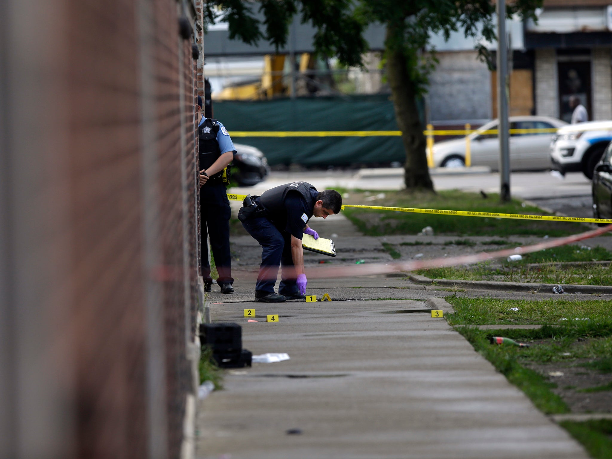 Chicago police officers and detectives investigate a shooting