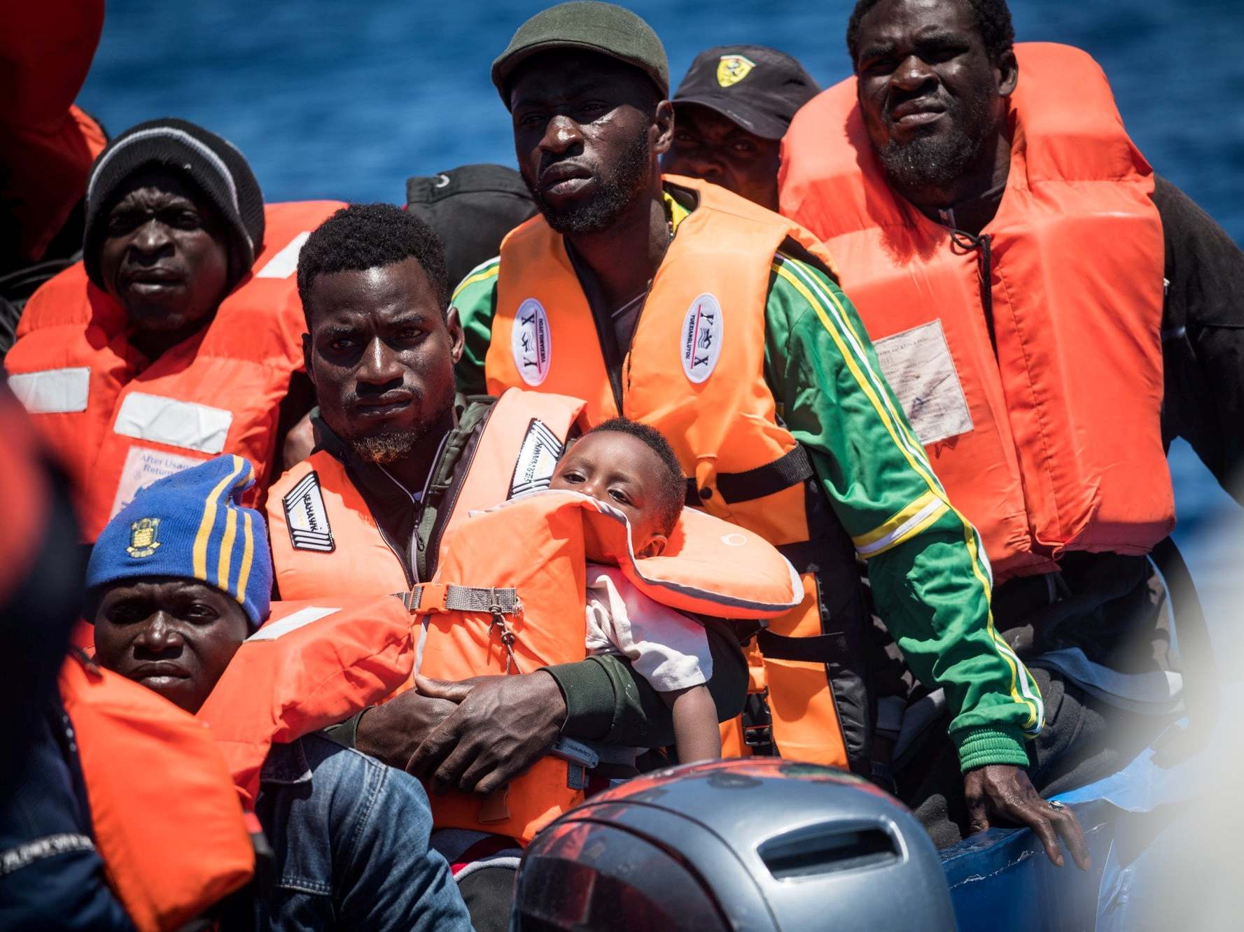 Refugees float on a dinghy before they are rescued off the coast of Lampedusa, Italy