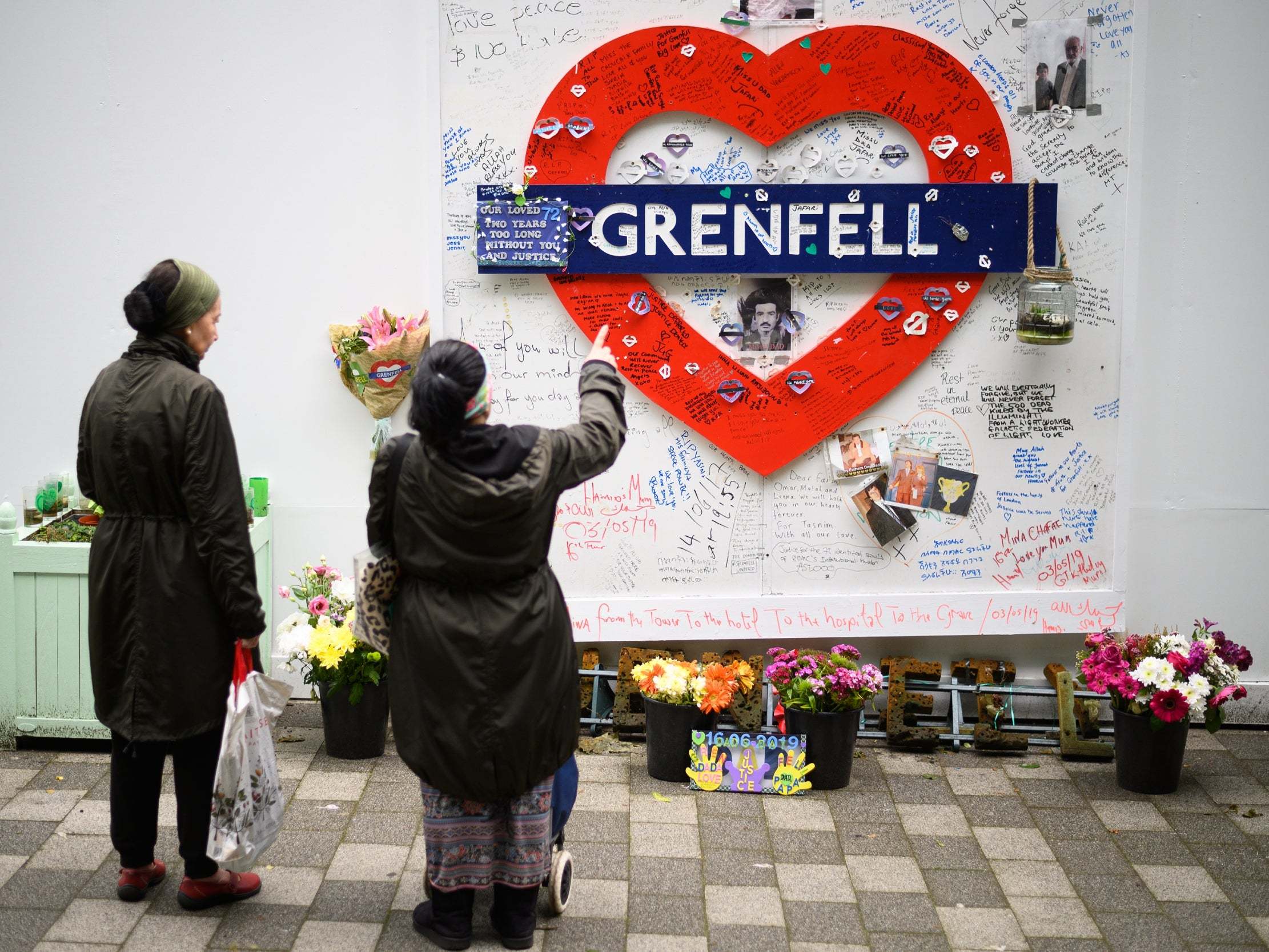 Locals look at a homemade tribute to Grenfell victims on the eve of the fire's second anniversary