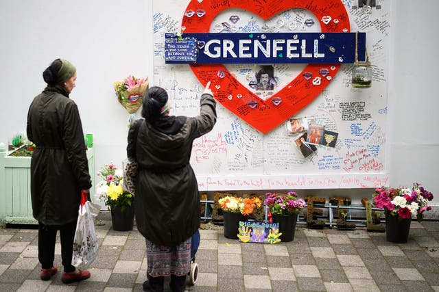 Locals look at a homemade tribute to Grenfell victims on the eve of the fire's second anniversary