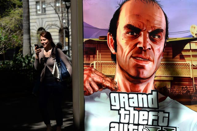 A woman walks past a billboard advertising the launch of console game Grand Theft Auto 5 in the central business district of Sydney on September 17, 2013